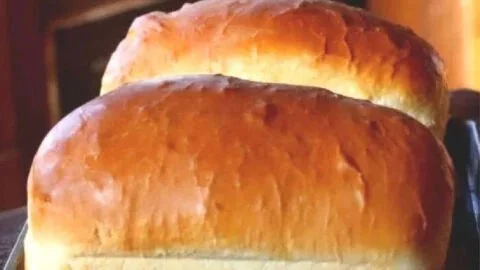 Freshly baked Amish white bread loaf on a wooden table
