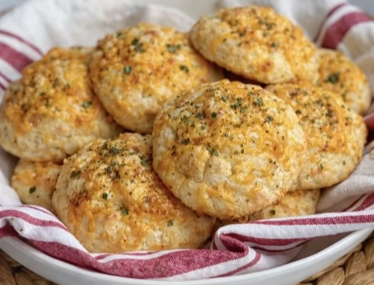 Freshly baked Cheddar Bay Biscuits served on a plate with herbs