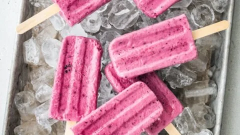 Colorful Greek yogurt popsicles with fresh fruits in a sunny setting