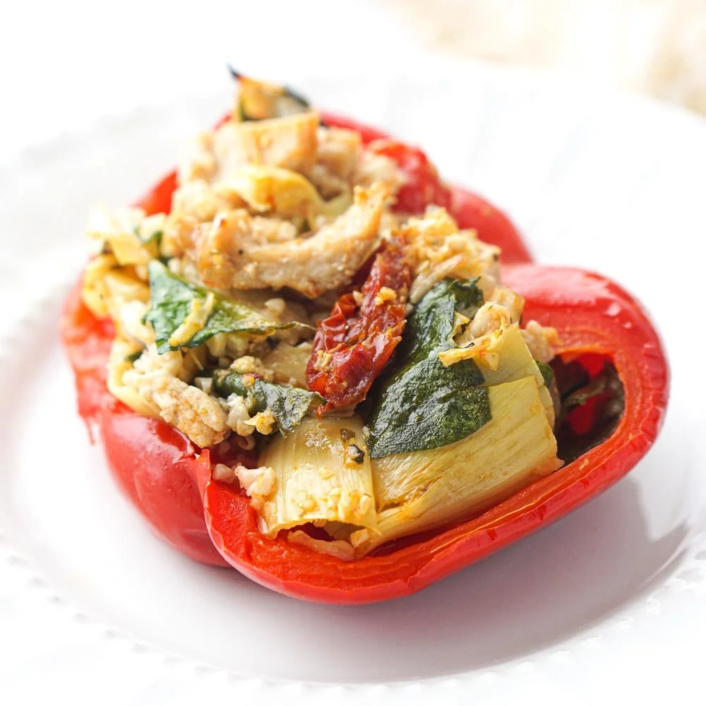 Mediterranean Chicken Stuffed Bell Peppers garnished with herbs
