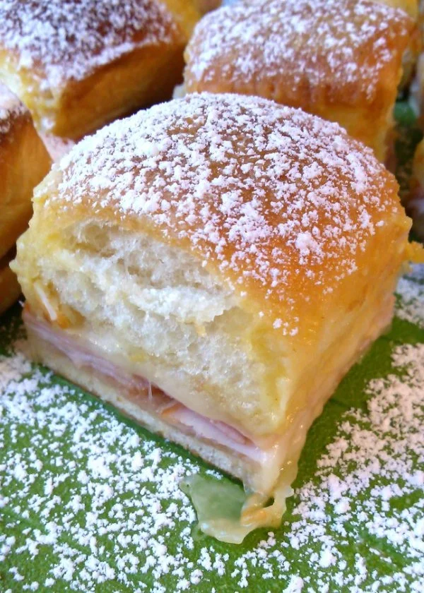 Plate of Monte Cristo sliders served with dipping sauce.