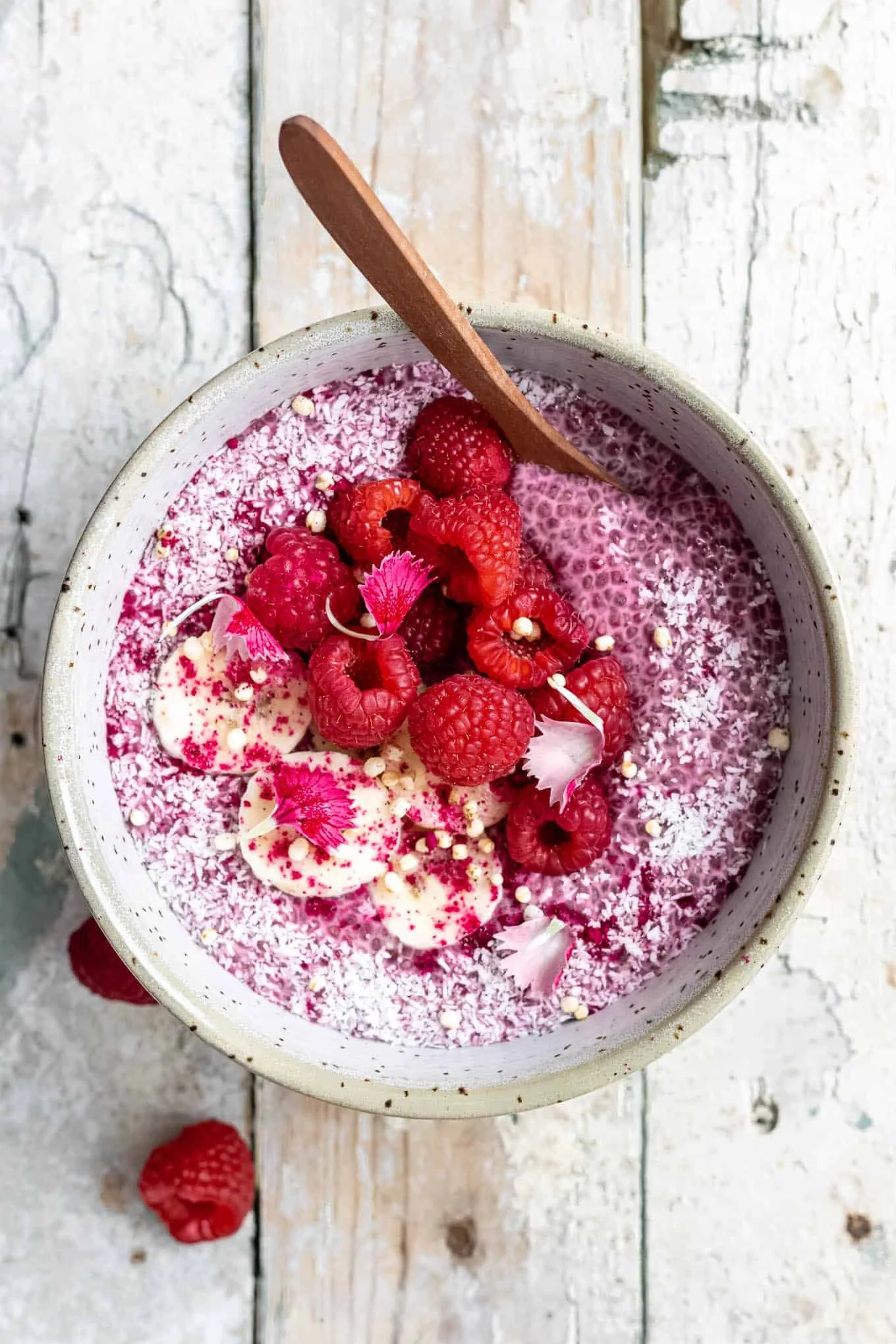 A bowl of Raspberry Chia Pudding topped with fresh raspberries and mint leaves