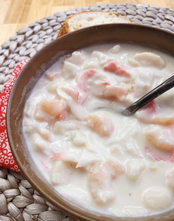 Bowl of creamy shellfish chowder with fresh ingredients