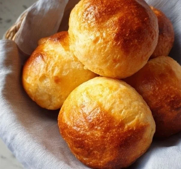 Freshly baked sourdough discard dinner rolls on a wooden table.