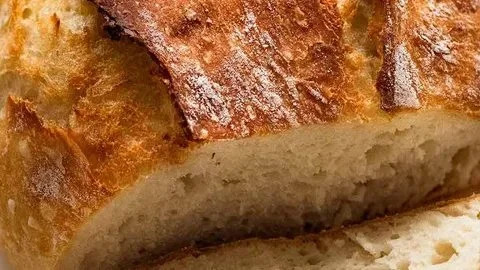 Freshly baked yeast bread loaf on a wooden table