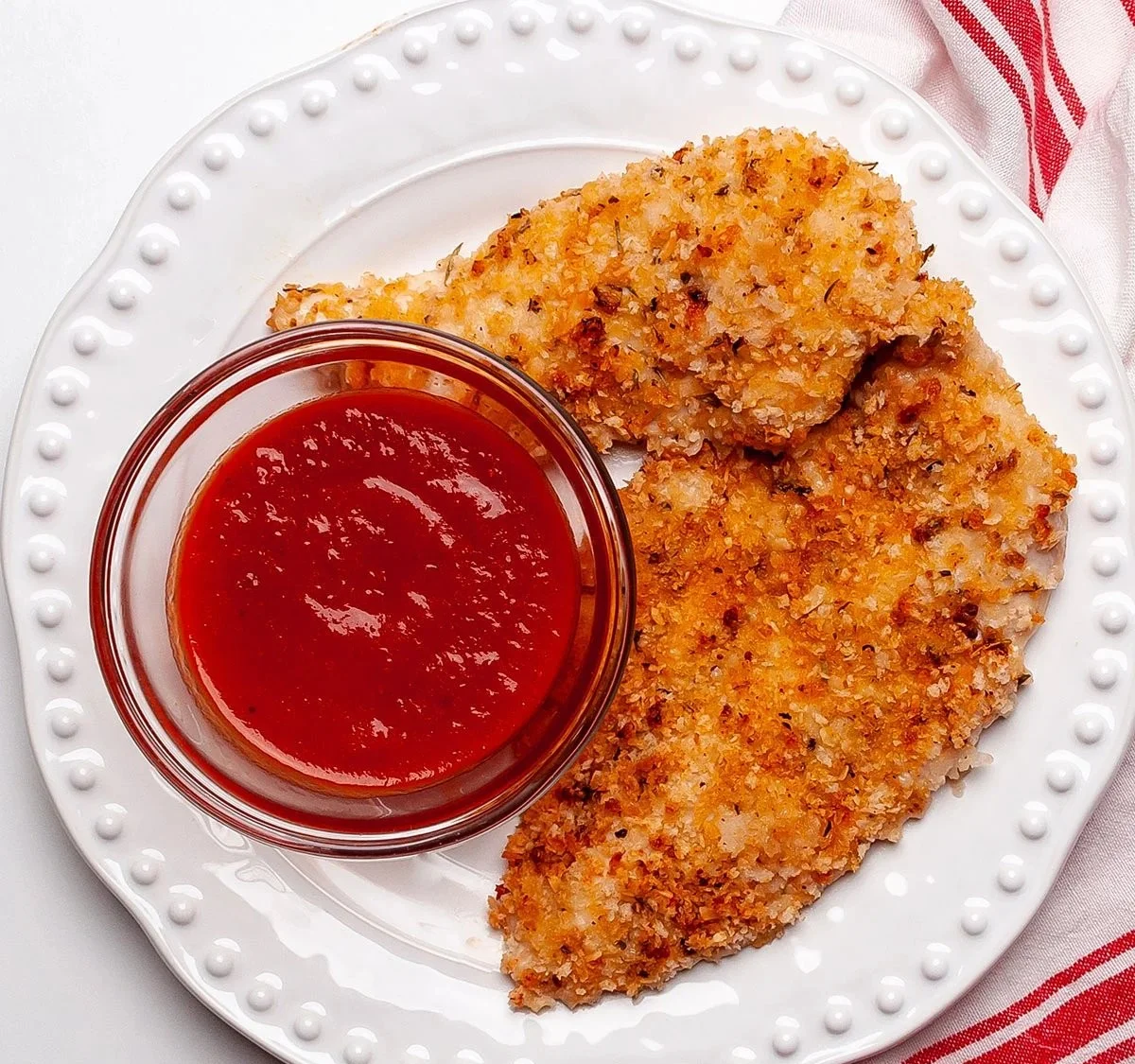 Crispy baked panko chicken on a plate garnished with herbs