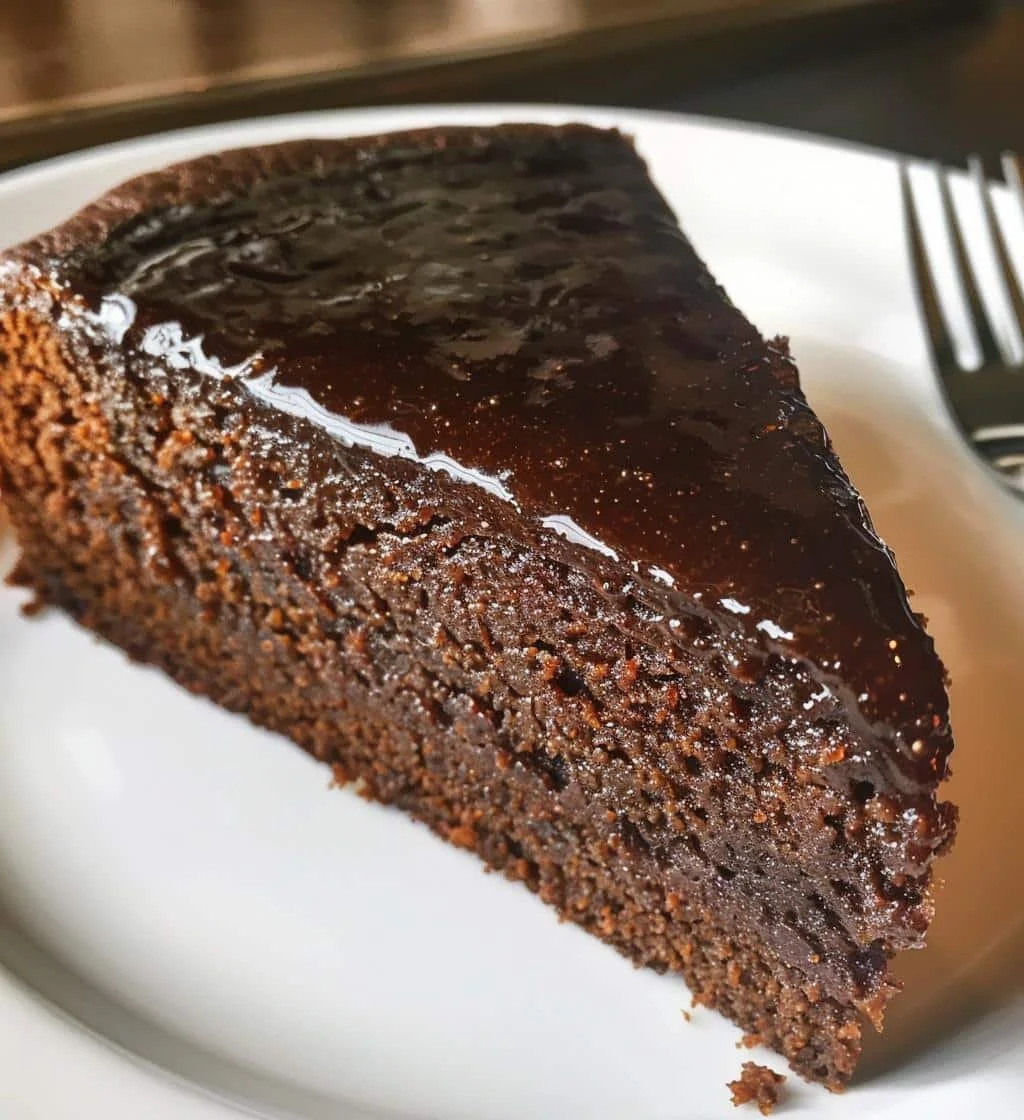 Slice of Edwardian Molasses Butter Cake topped with buttercream and served on a plate.