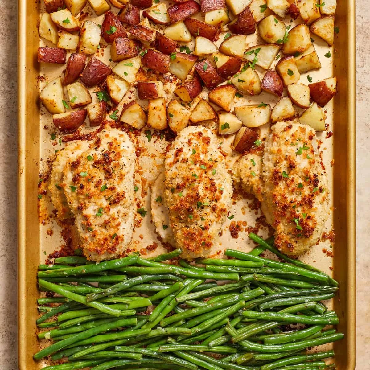 Parmesan Crusted Chicken on a sheet pan with vegetables, ready for dinner.