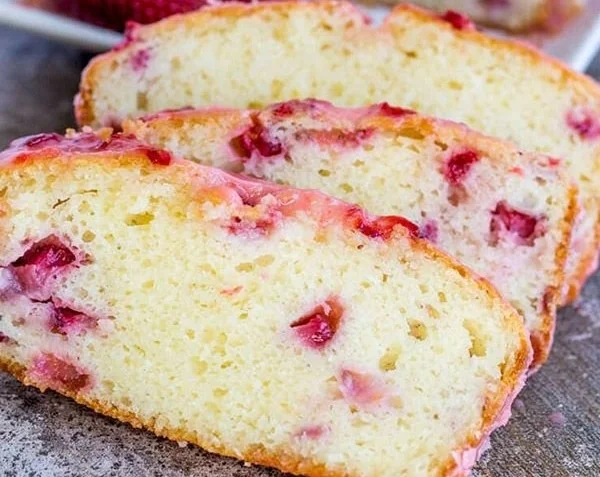 Slice of moist strawberry pound cake topped with fresh strawberries