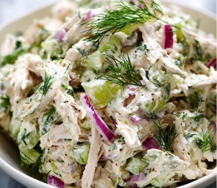 Bowl of healthy chicken salad with fresh vegetables and herbs