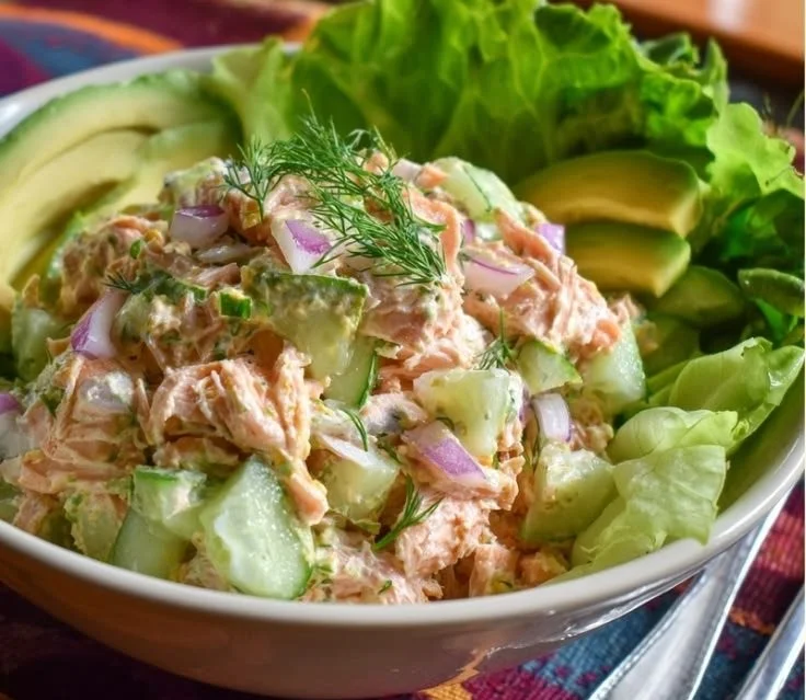Healthy salmon salad with cucumber and vegetables on a plate.
