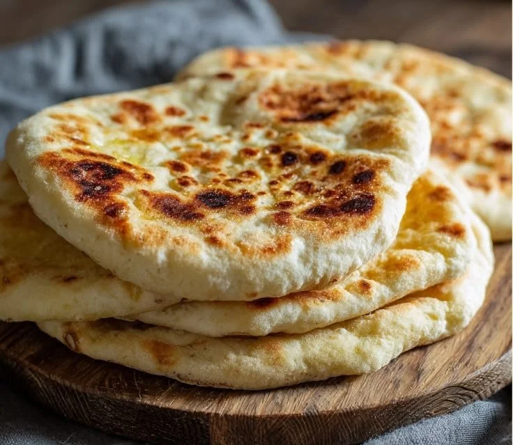 Freshly baked sourdough pita bread on a wooden table